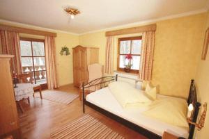 a bedroom with a bed and two windows at Eichenhof in Waging am See