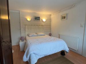 um quarto com uma cama branca e 2 almofadas em Gîte Cornimont, 2 pièces, 2 personnes - FR-1-589-17 em Cornimont