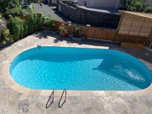 une grande piscine bleue dans une cour dans l'établissement Malaury, splendide villa avec piscine chauffée, à Saint-Gilles les Bains