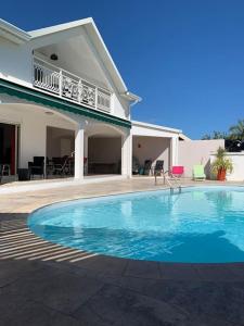 - une piscine en face d'une maison dans l'établissement Malaury, splendide villa avec piscine chauffée, à Saint-Gilles les Bains