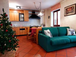 una sala de estar con un sofá verde y un árbol de Navidad en Appartamento Pieve, en Pieve Tesino