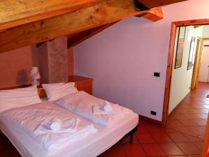 1 dormitorio con 1 cama con sábanas blancas en Appartamento Pieve, en Pieve Tesino
