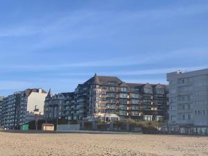 een gebouw aan het strand naast een zandstrand bij De Witte Berg met zonnig zeezicht & uniek terras! in De Panne