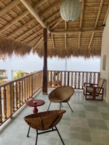 a patio with chairs and a table on a deck at Halcyon Mawella in Tangalle
