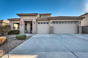 a house with two garage doors and a driveway at Heated Pool, Gas Grill and Yard Phoenix Retreat! in Avondale