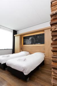 フェンラユにあるHotel Hulsmanのベッド3台と窓が備わる客室です。
