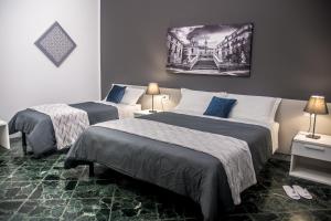 una camera d'albergo con due letti e un dipinto sul muro di Amarillo a Palermo