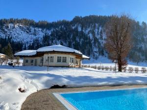 a house in the snow with a swimming pool at Berghof-Chalet in Erpfendorf