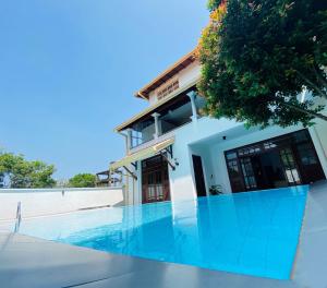 una casa con piscina delante de una casa en Villa 59, en Galle