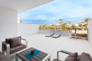 a patio with a couch and chairs on a balcony at Apartment in Mil Palmeras in Pilar de la Horadada