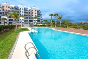 a swimming pool in front of a apartment building at Apartment in Mil Palmeras in Pilar de la Horadada