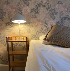 a bedroom with a bed and a lamp and a chair at Bergsgården Hotell & Konferens in Bergsgården