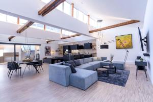 uma sala de estar com um sofá, uma mesa e cadeiras em Luxus Wellness Loft - 245qm - Designwohnen im Zentrum em Gütersloh