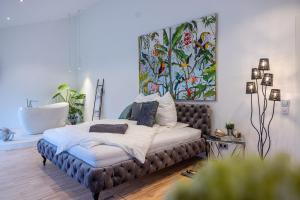 a bedroom with a bed with a large painting on the wall at Luxus Wellness Loft - 245qm - Designwohnen im Zentrum in Gütersloh