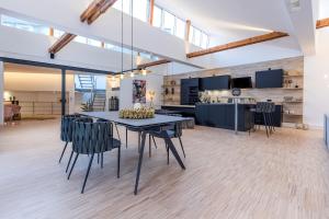 Luxus Wellness Loft - 245qm - Designwohnen im Zentrum في غوترسلوه: غرفة طعام ومطبخ مع طاولة وكراسي