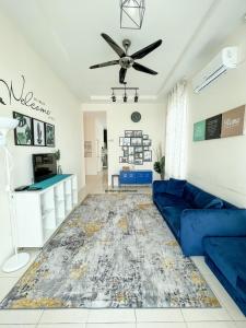 a living room with a blue couch and a ceiling fan at Sisikami Guesthouse in Changlun