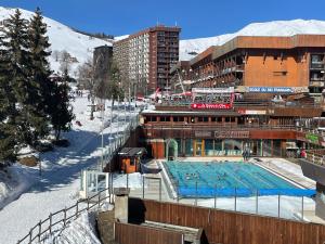 un edificio con piscina en la nieve en Le Corbier résidence Les Pistes, en Le Corbier