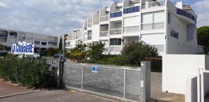a fence in front of a building with a building at Studio vue port, parking privé, terrasse, clim in Le Grau-du-Roi