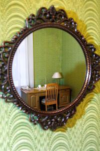 a mirror on a wall with a desk and a chair at Hotel Park Lion Bridge in Saint Petersburg