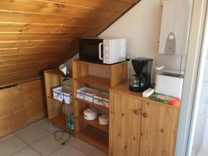 a kitchen with a microwave on top of a wooden cabinet at Sonnige Dachgeschoßwohnung in Niederkassel