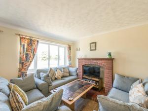 a living room with a couch and a fireplace at The Bungalow in Cleobury Mortimer