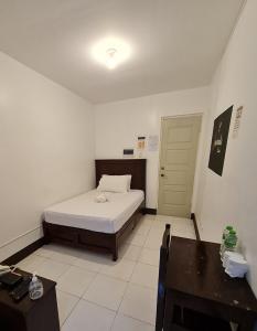 AMARANTA SUITES في مدينة دافاو: غرفة نوم بسرير وطاولة وباب