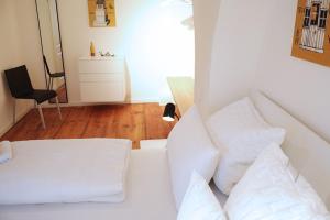 a white bed with white pillows in a room at Wassergasse 11 in Regensburg