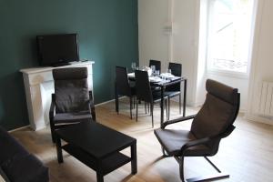 a dining room with a table and chairs and a television at Les locations d'Argol in Argol