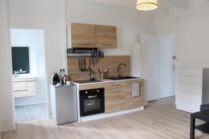 a kitchen with a sink and a refrigerator at Les locations d'Argol in Argol