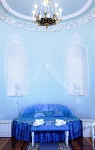 a blue bedroom with a bed and a chandelier at Hotel Park Lion Bridge in Saint Petersburg