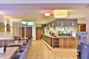 a restaurant with tables and chairs and a kitchen at City-Hotel-Wolgast in Wolgast