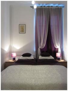 ワルシャワにあるUnique Warsaw Center Apartmentのベッドルーム1室(紫色のカーテンとランプ2つ付)