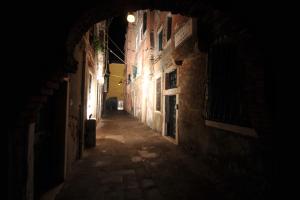 eine leere Gasse in der Nacht in einer alten Stadt in der Unterkunft CALLE DE LA COMARE in Venedig