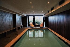 a swimming pool in a room with a table and chairs at Hotel Cristallo in Alagna Valsesia
