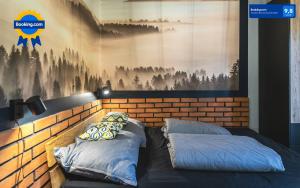 sypialnia z 2 poduszkami na łóżku obok ściany w obiekcie Apartamenty SPOKOLOKO Skrzyczne Residence Korzenny i Kamienny w Szczyrku