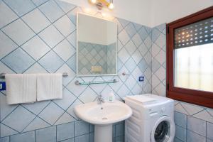 a bathroom with a sink and a washing machine at Casa Osala in Orosei