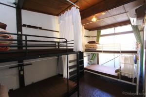 a room with two bunk beds and a window at Otohaya Guesthouse in Nagoya