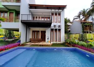 een huis met een zwembad voor een gebouw bij Villa Mawar Syariah in Bandung
