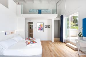 a white living room with a white bed and a desk at Calapetra Resort in Fontane Bianche