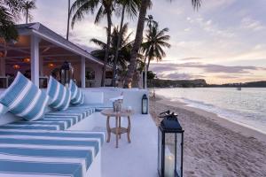 a beach bar with blue and white pillows and a table at Tembo Beach Club & Resort in Koh Samui 