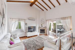a living room with white furniture and a fireplace at Los Naranjos 7 in Atamaría