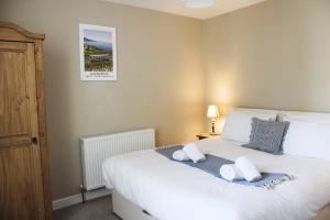 - une chambre avec un grand lit blanc et 2 oreillers dans l'établissement The Clifton Holiday Apartment Llandudno Centre, à Llandudno