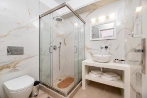 a bathroom with a shower and a toilet and a sink at Villa Waves in Monolithos
