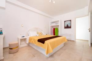 a white bedroom with a bed with a yellow blanket at Villa Waves in Monolithos +18 photos
