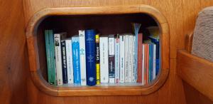 een boekenplank gevuld met veel boeken bij Audierne Yachting in Audierne