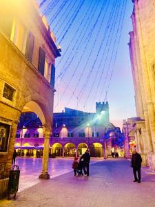 Un gruppo di persone che camminano per la piazza della città di Lovely 2 bedroom apartment steps from Ascoli's stunning Piazza del Popolo ad Ascoli Piceno