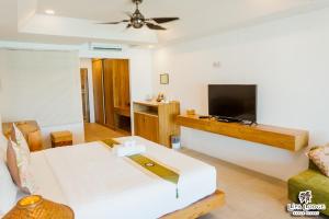 a living room with a couch and a flat screen tv at Lipa Lodge Beach Resort in Lipa Noi