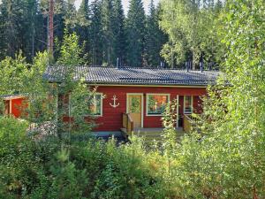 a red cabin in the middle of a forest at Villa Maria Cottages in Jaala