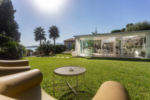 ein Haus mit einer Liegewiese mit einem Tisch und Stühlen in der Unterkunft Calapetra Resort in Fontane Bianche