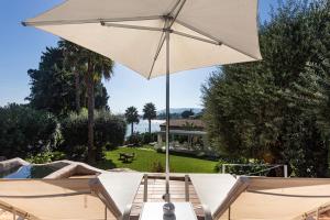 una sombrilla blanca sentada en una mesa junto a una piscina en Calapetra Resort en Fontane Bianche